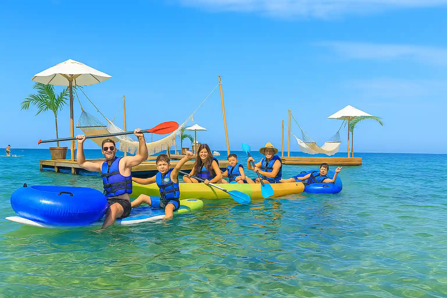 Familia disfrutando de un paseo en kayak sobre aguas cristalinas en un destino turístico ideal para vivir aventuras acuáticas.