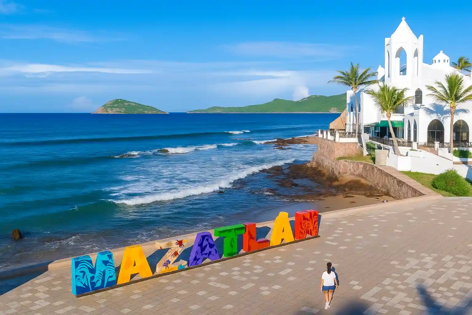Vista panorámica de la playa de Mazatlán con su colorido letrero turístico, ideal para promover destinos de sol y mar en México.